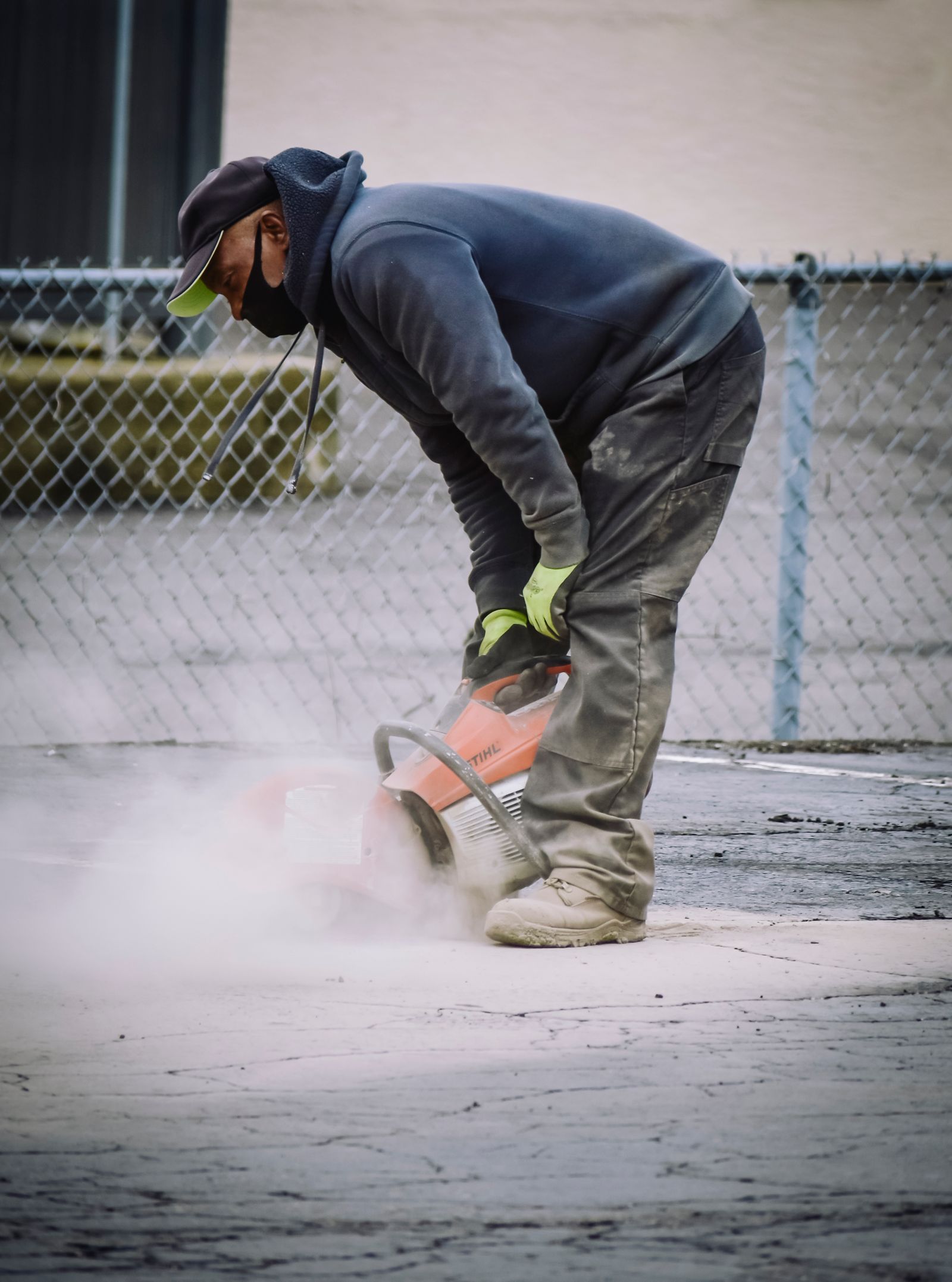 Construction worker cutting damaged concrete during repair work