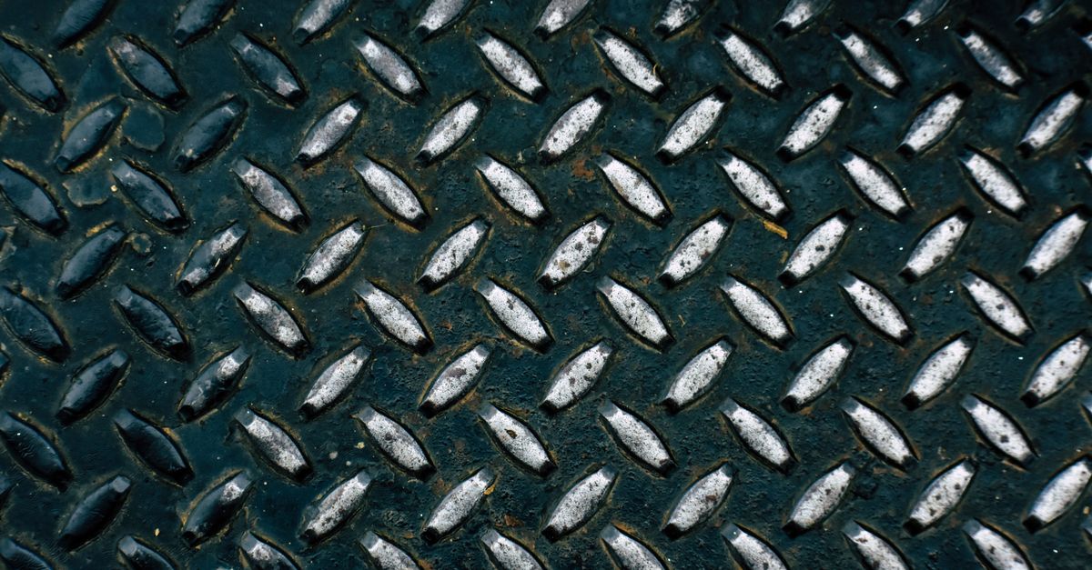 China Iron Ore Futures Slip in Midday Trade as Ferrous Metals Weaken Detailed view of a diamond plate metal surface showcasing its rugged pattern.
