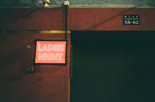 Free Neon sign advertising Ladies Night event, located on D'Aguilar Street. Stock Photo