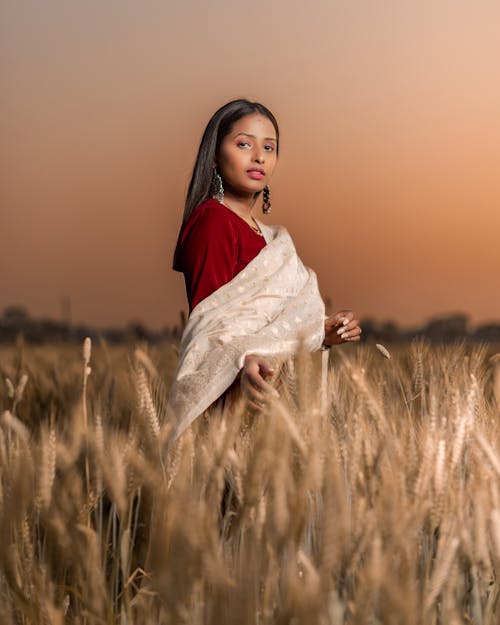 Photo of a Woman Standing in a Wheat Field