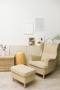 Cozy living room with beige armchair, pouf, and minimalist decor. - Fotografer Sidoarjo