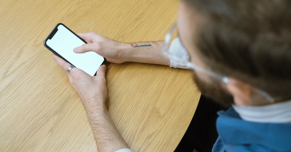 Person liest Google-Bewertungen zu einem Fitnessstudio auf dem Smartphone