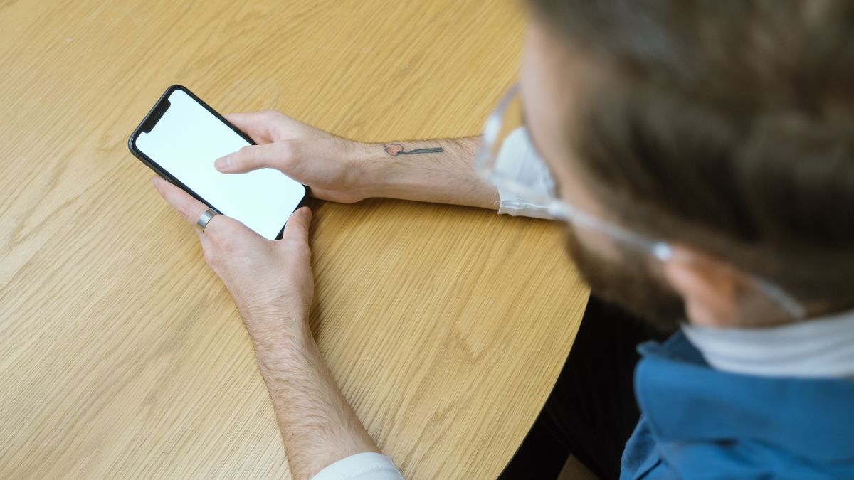 テーブルでスマートフォンの画面を操作している手元のイメージ