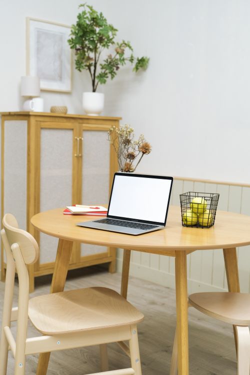 Free A minimalist home office setup featuring a wooden table, laptop, and decorative plants. Stock Photo