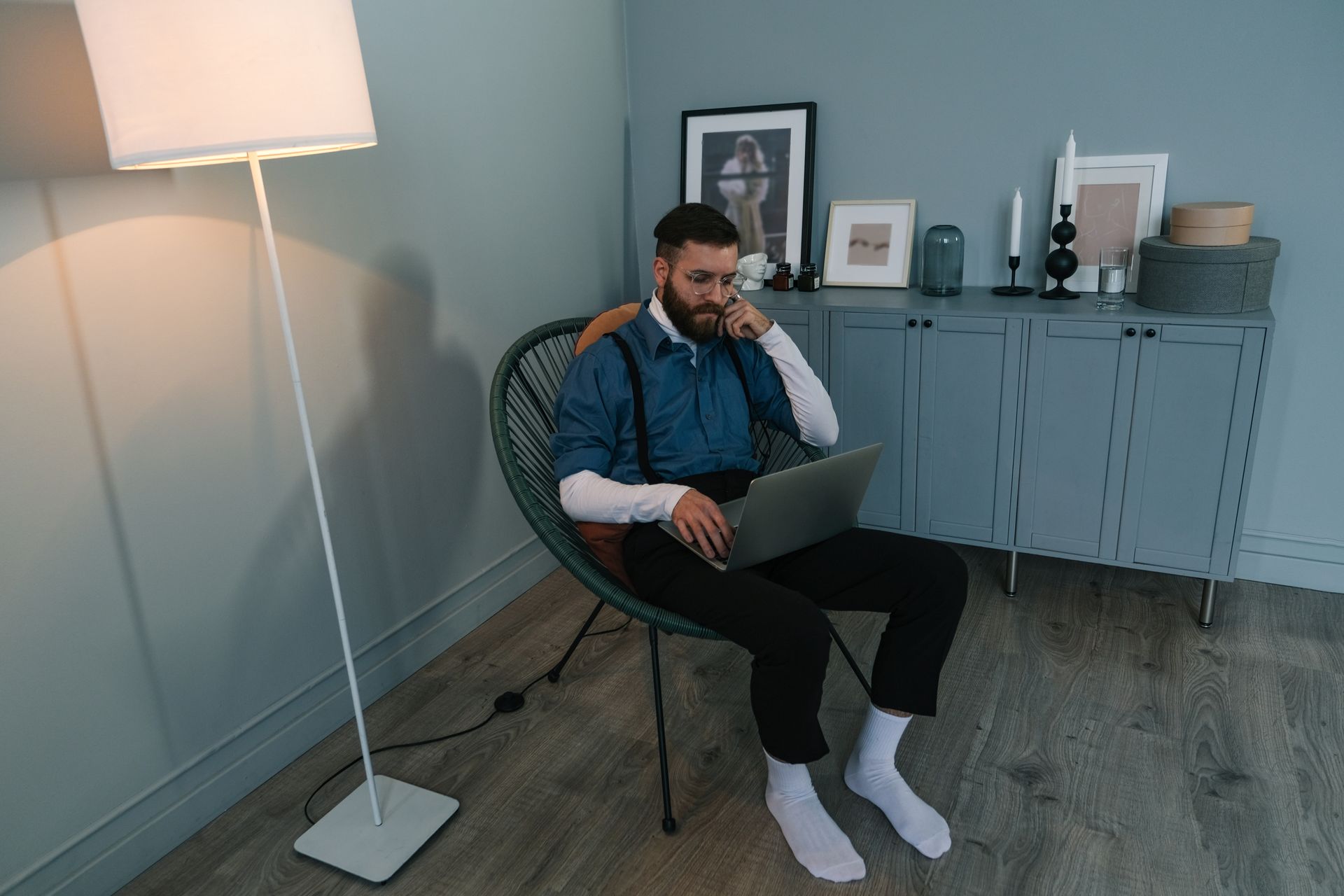 A man in a modern home office setting working on a laptop. Perfect for work from home concepts.