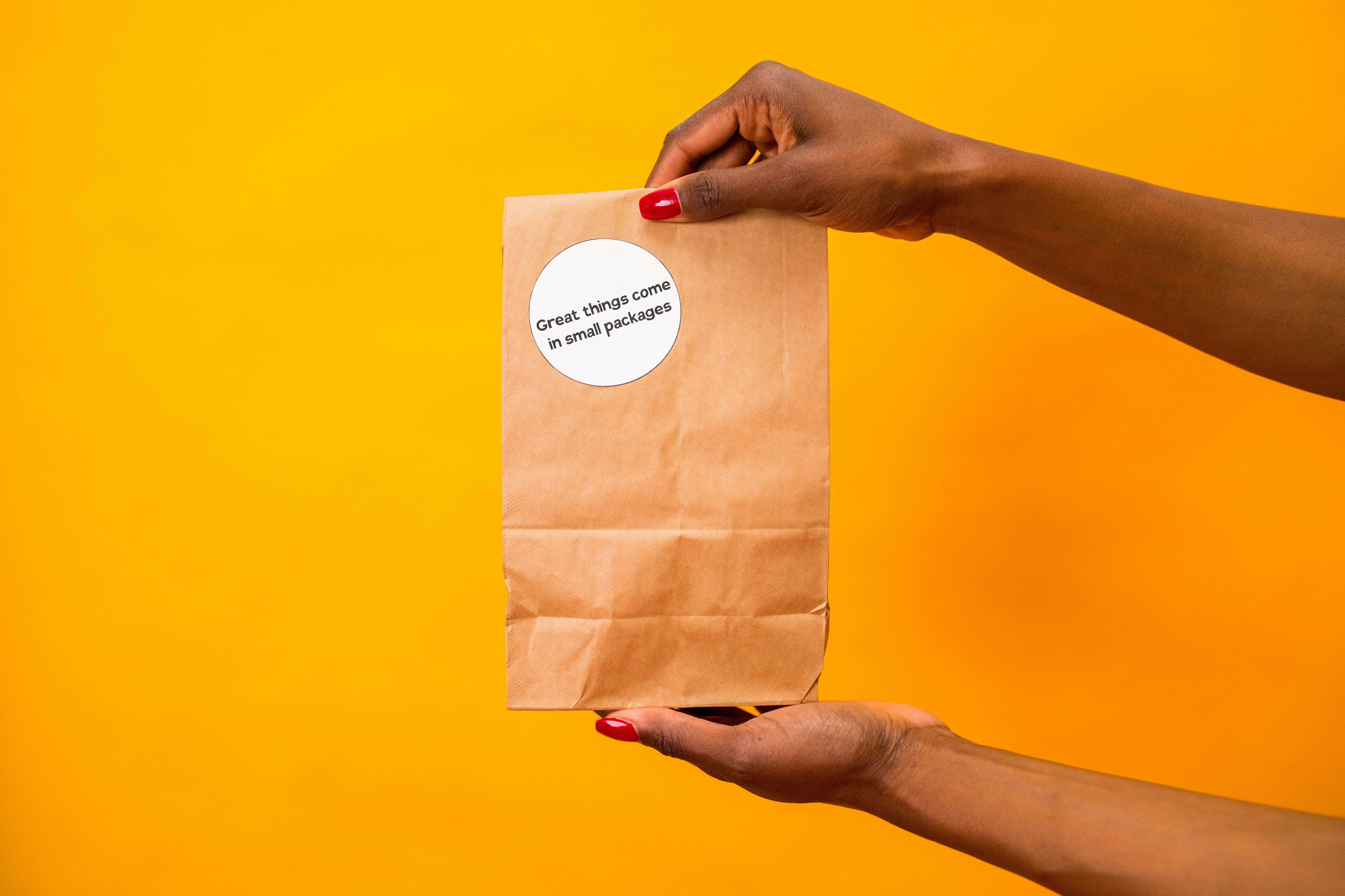 Hands Holding a Brown Paper · Free Stock Photo