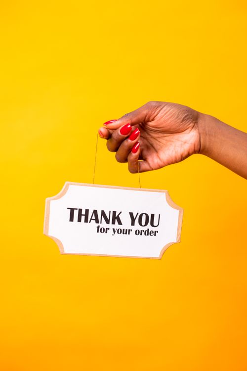 hand holding thank you for your order sign