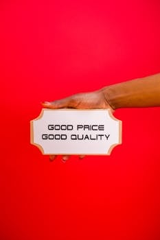 A hand holding a sign with 'Good Price, Good Quality' text against a bright red background.