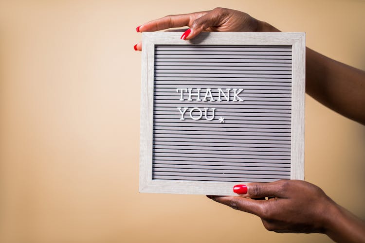 A Person Holding A Gray Thank You Signage