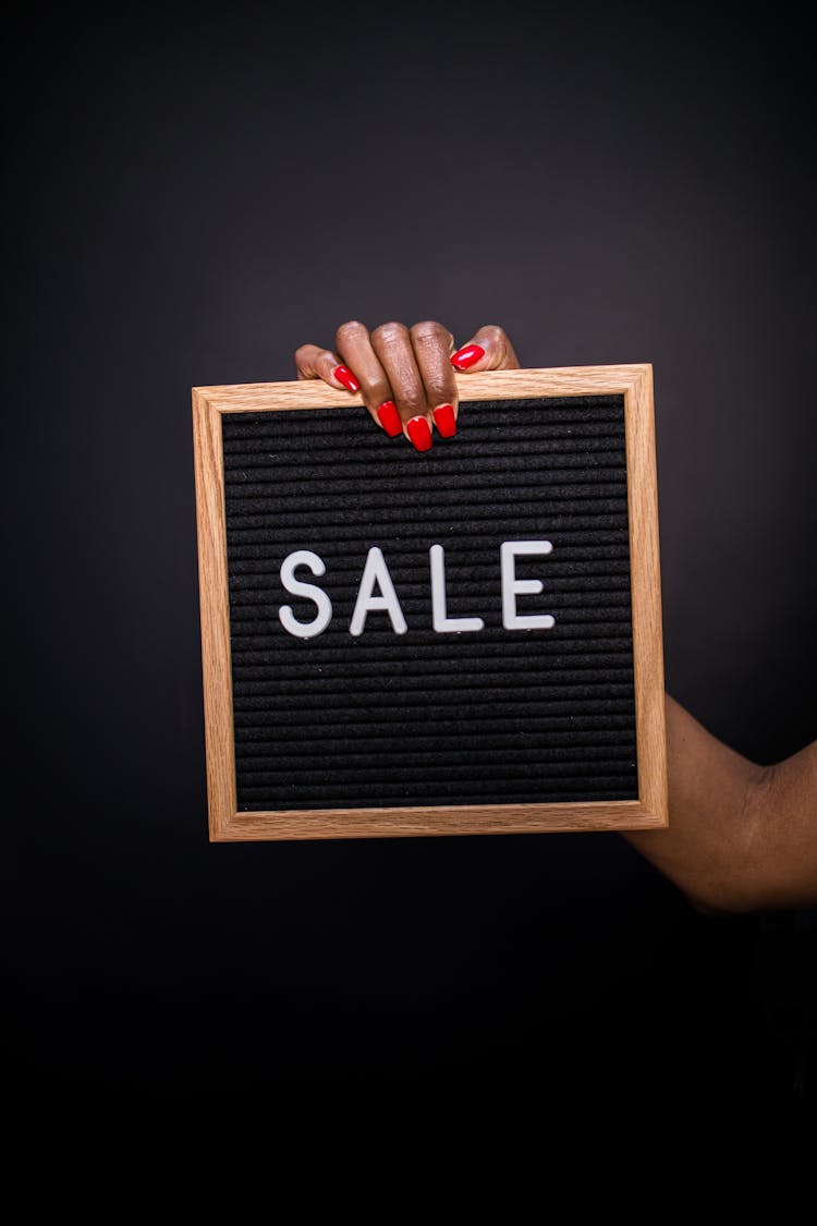 A Person Holding A Sale Signage