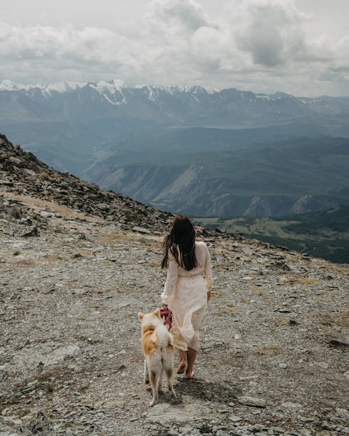 Woman and Her Dog Walking in Mountains 
