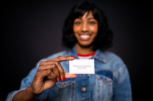 Woman Smiling and Holding a Thank You Card 