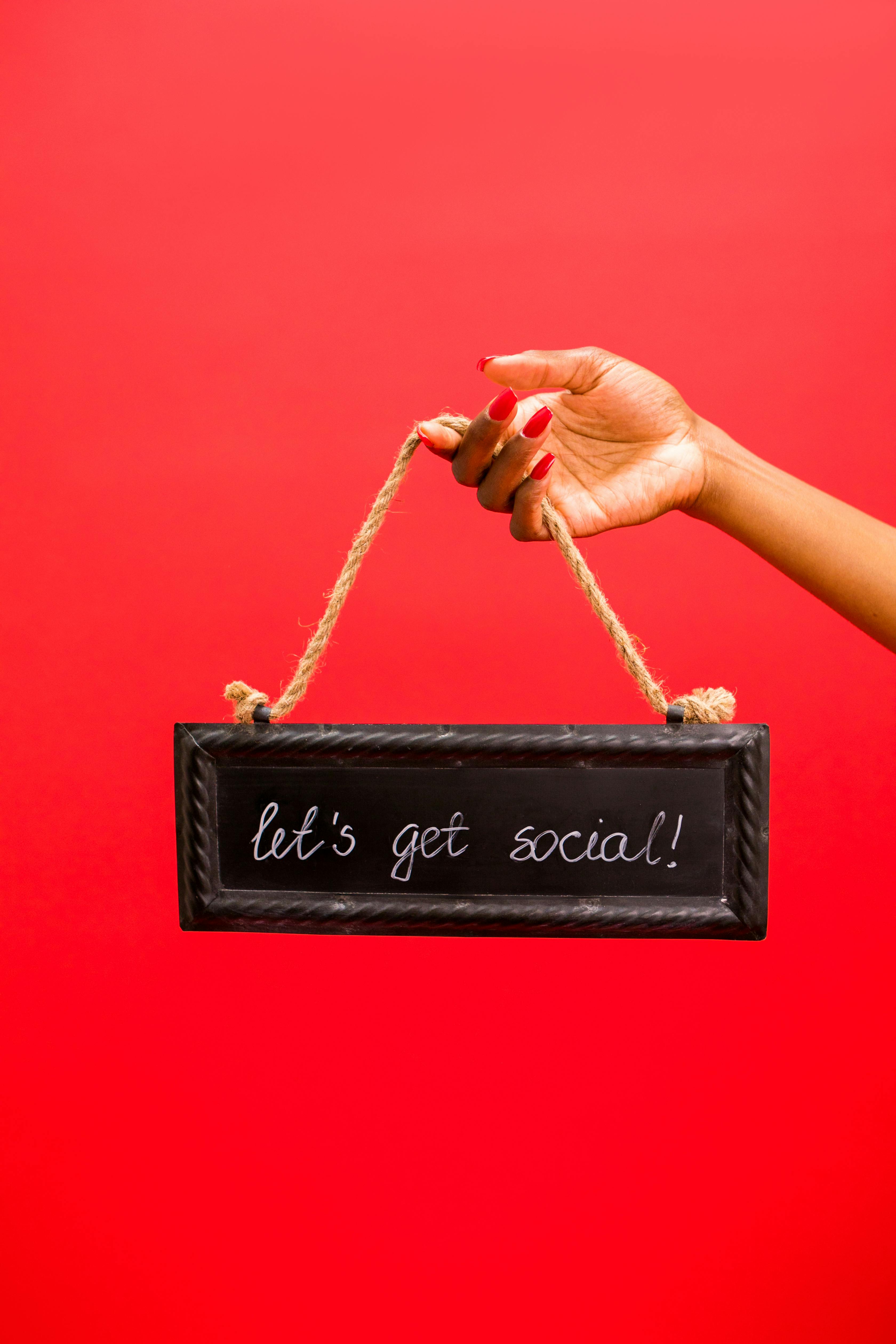 person holding a chalkboard with a text saying lets get social