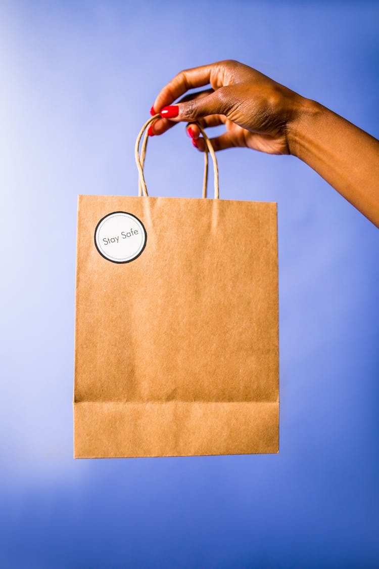 Person Holding A Brown Paper Bag