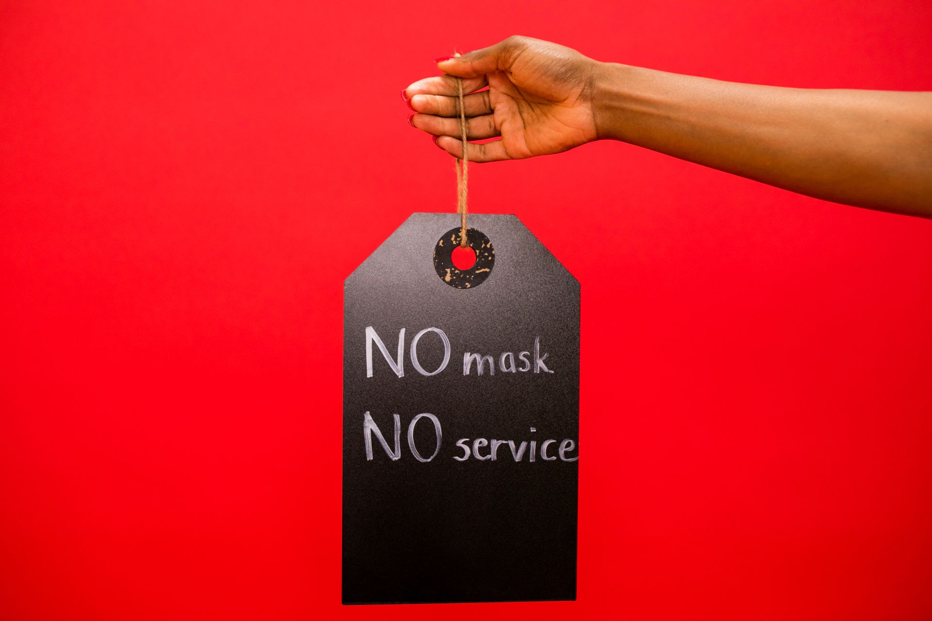 A Person Holding a Sign Board No Mask No Service