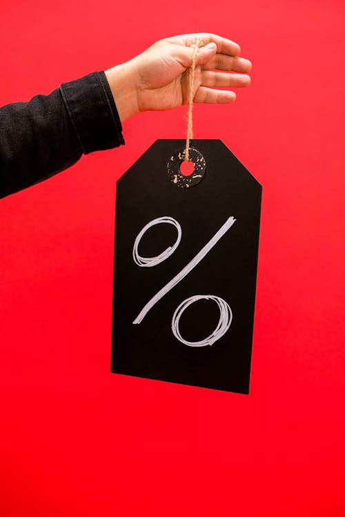 Person Holding a Chalkboard with a Percentage Sign 
