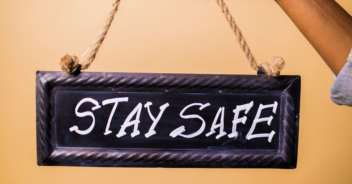 Hey Safe A Person Holding a Stay Safe Sign Board · Free Stock Photo