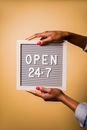 A Person Holding Letter Board with Advisory Open 24-7
