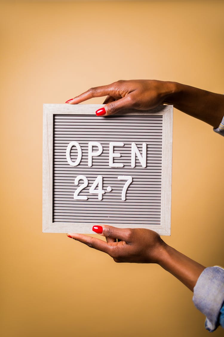 A Person Holding Letter Board With Advisory Open 24-7