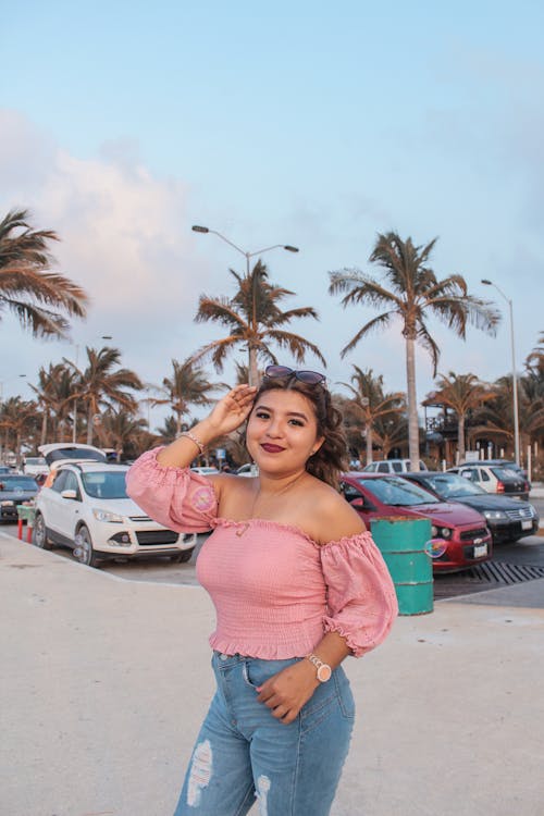 Beautiful Woman in a Pink Top Standing Near a Parking Lot
