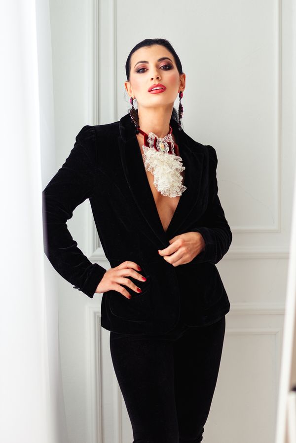 Elegant woman over 40 in a black velvet blazer with silk trousers
