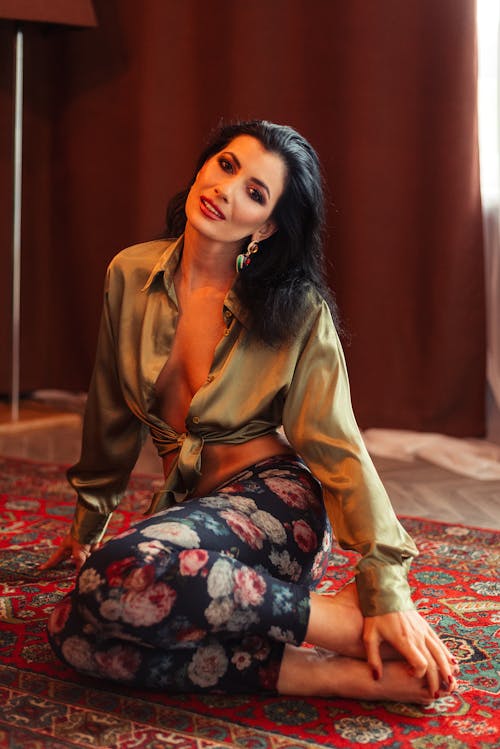 Stylish woman sitting on carpet
