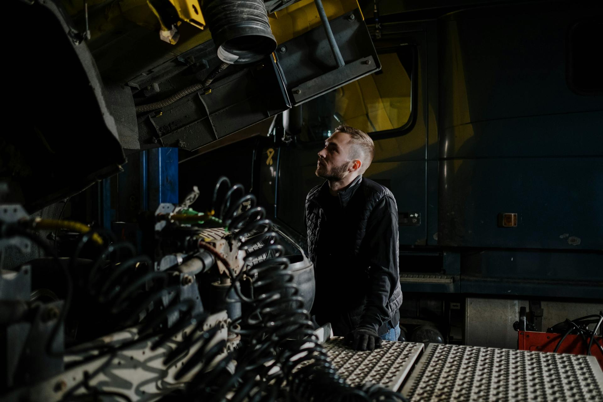 Mechanic Standing and Looking at a Truck in the Garage