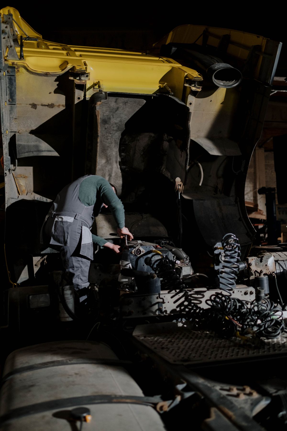 Mechanic working on a truck engine at night