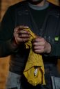 Crop anonymous male mechanic in uniform wiping greased hands while standing in repair workshop
