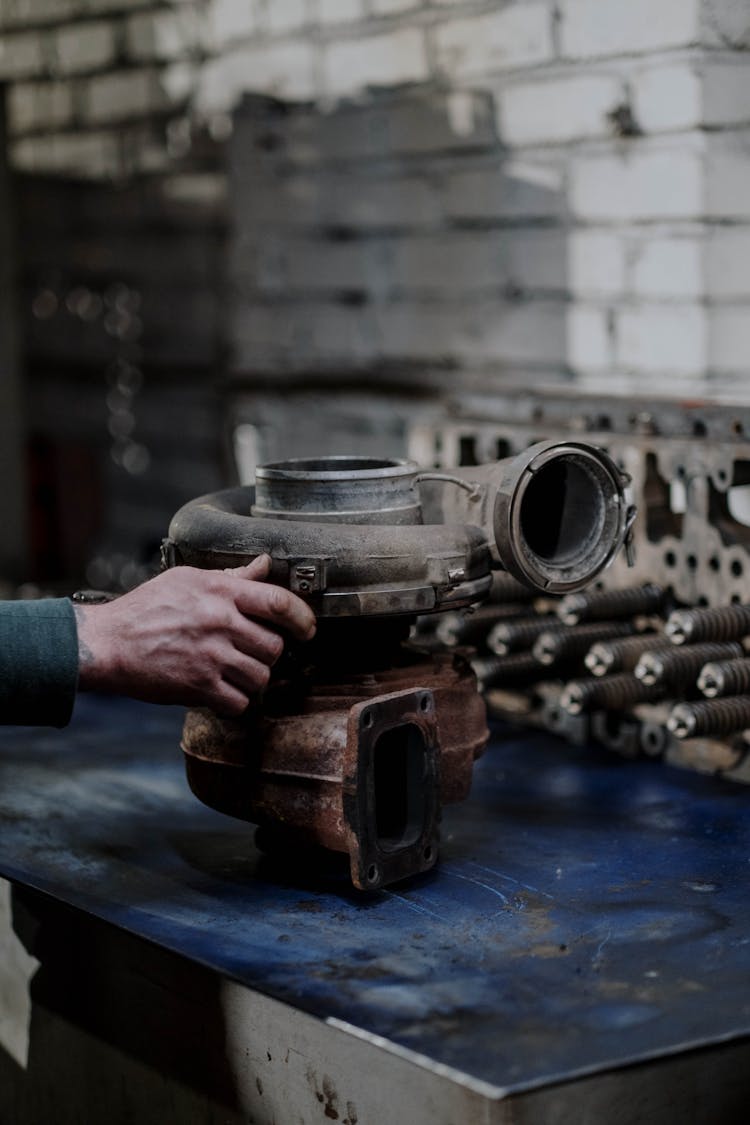 Person Holding A Rusty Engine Turbo