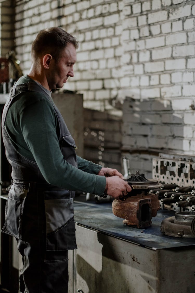 A Man Working On A Car Mechanism