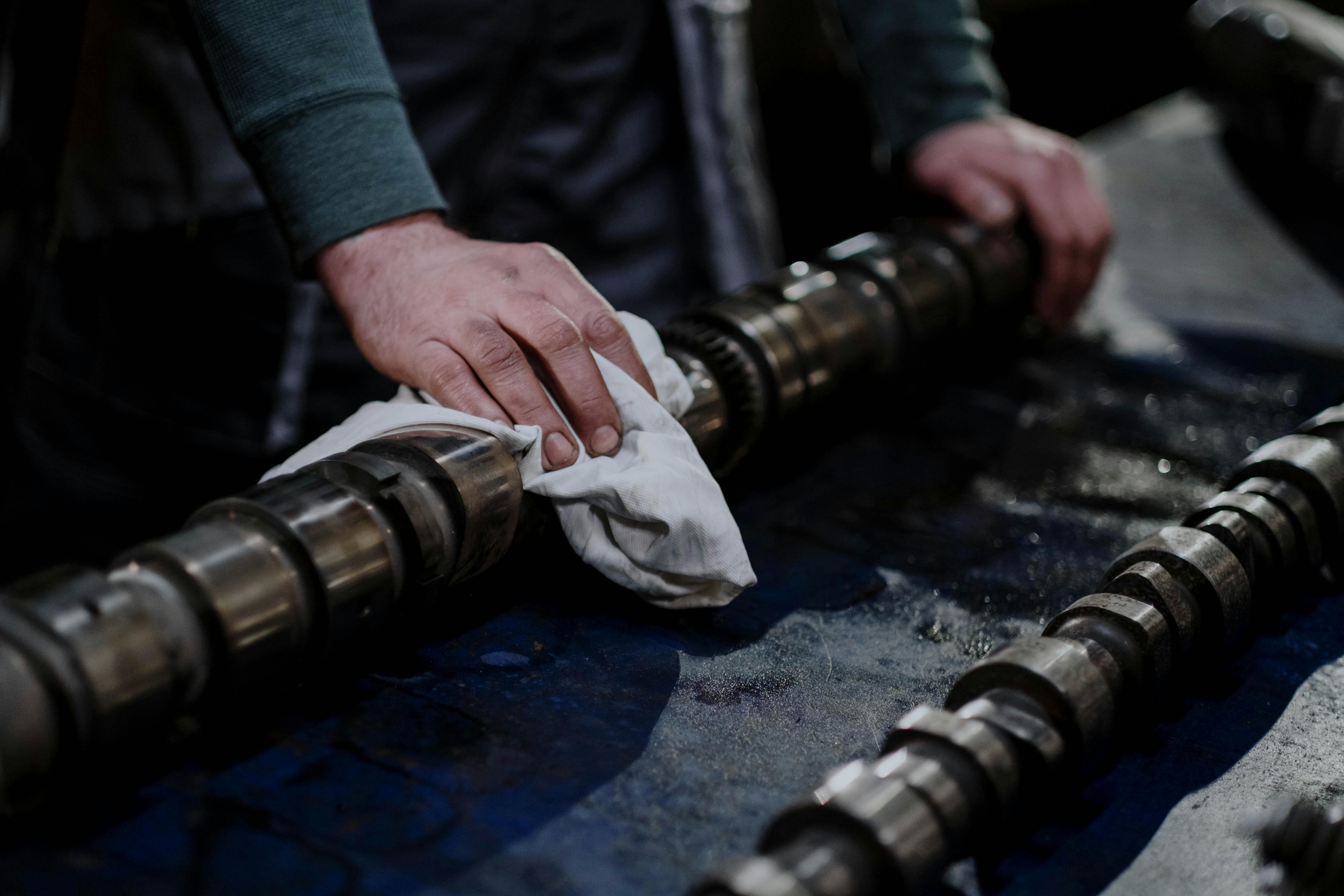 A Person Wiping a Part of a Metal Engine