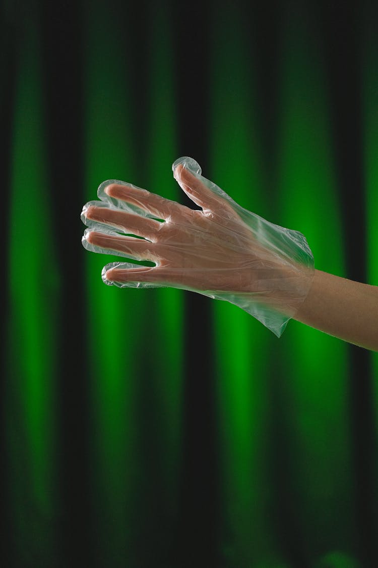 Hand In Protective Glove On Green Background