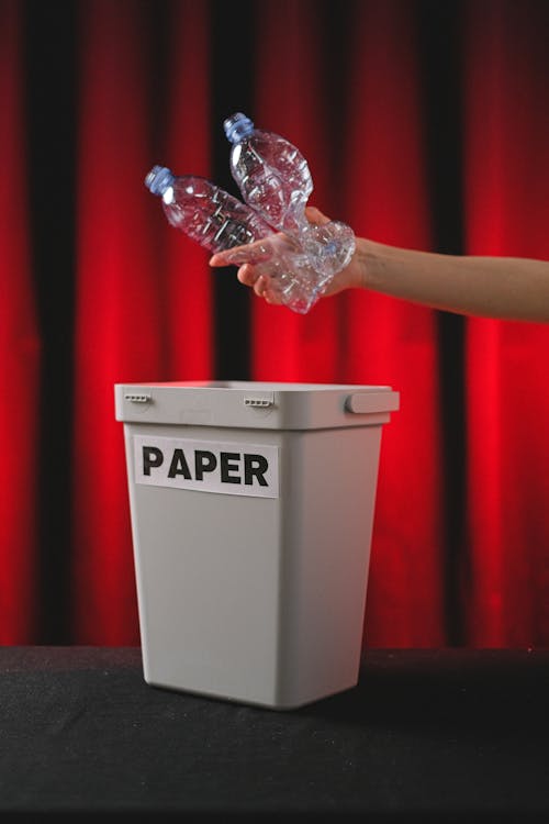 
A Person Throwing Plastic Bottles in the Trash Bin