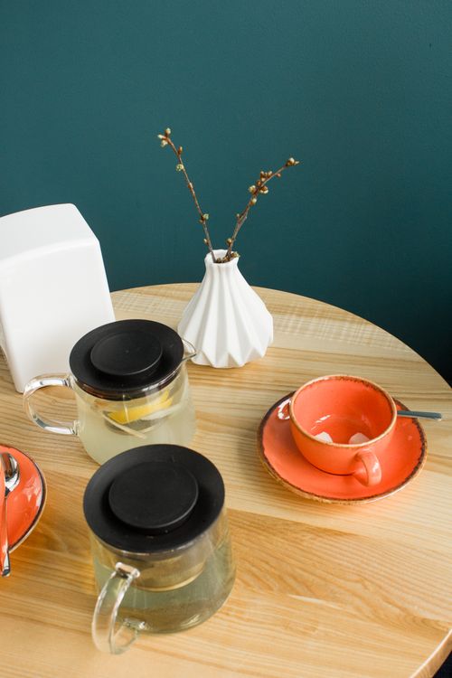 Free Stylish glass teapots and vibrant teacup on a wooden table, perfect for relaxing teatime. Stock Photo