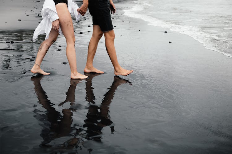 Legs Of Couple Walking On Beach