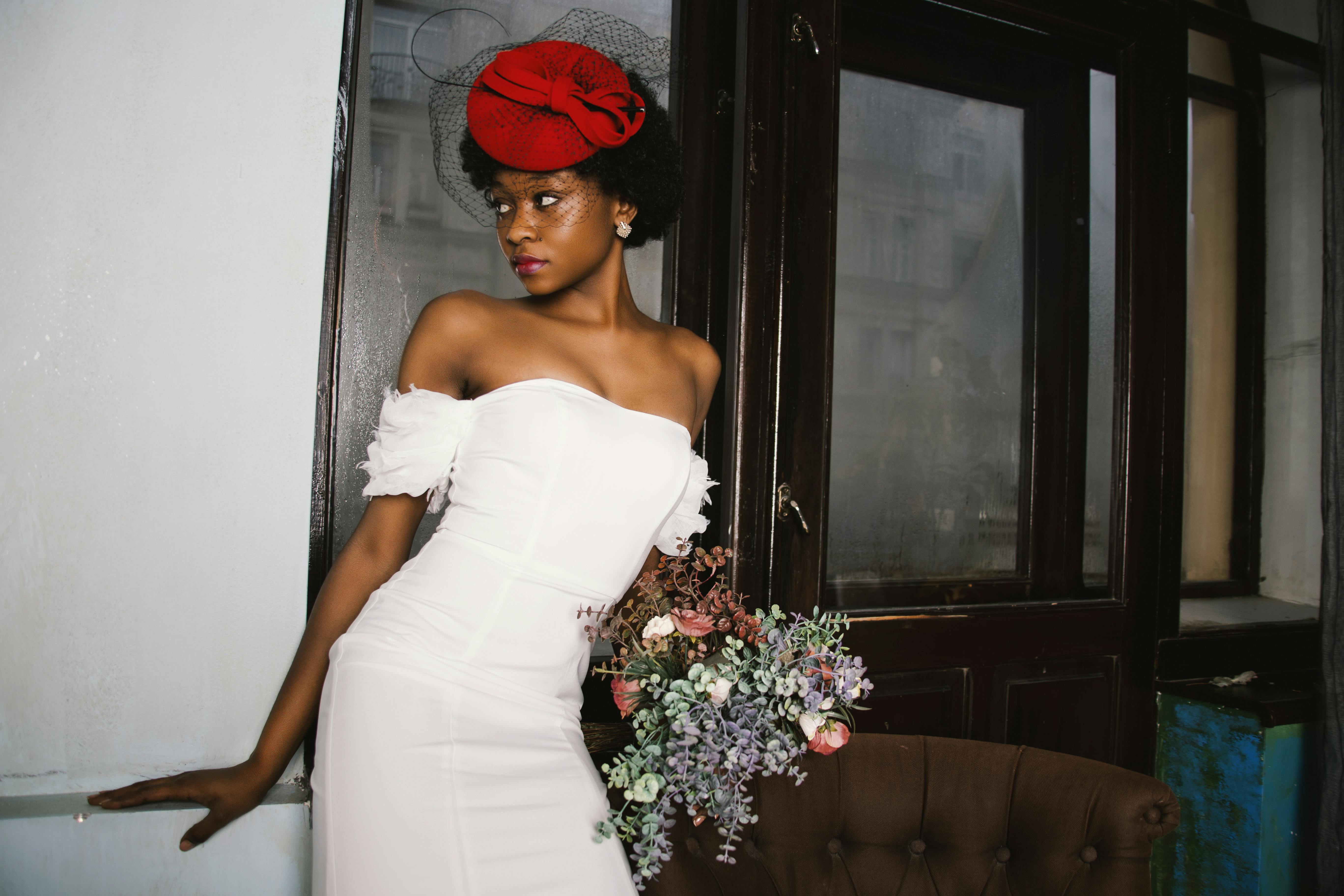 woman in white off shoulder dress holding bouquet