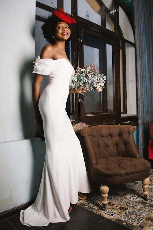 Mujer En Vestido Blanco Con Hombros Descubiertos Con Ramo De Flores Blancas