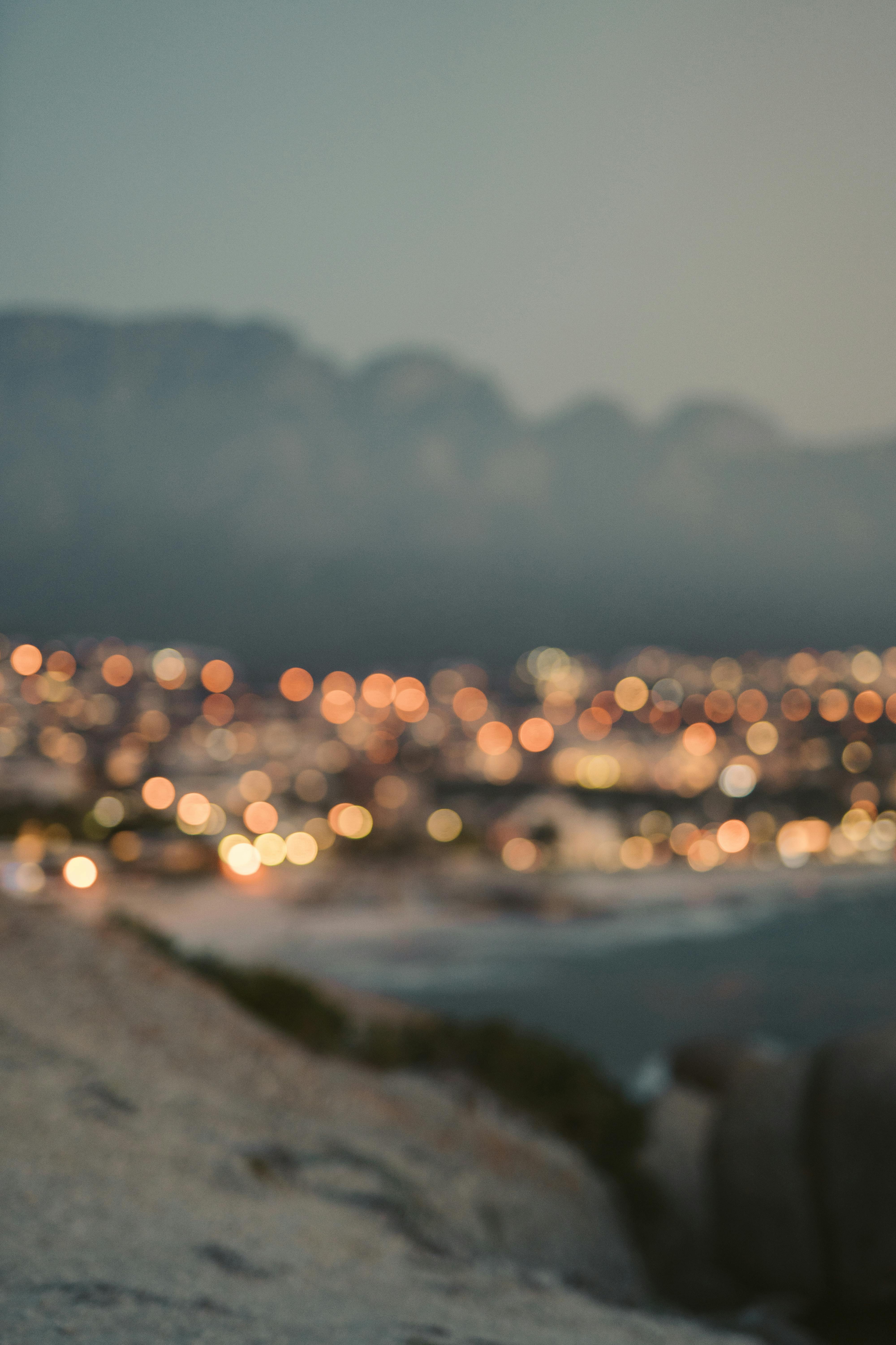 Captivating blurred city lights create a serene atmosphere at dusk near the coast.