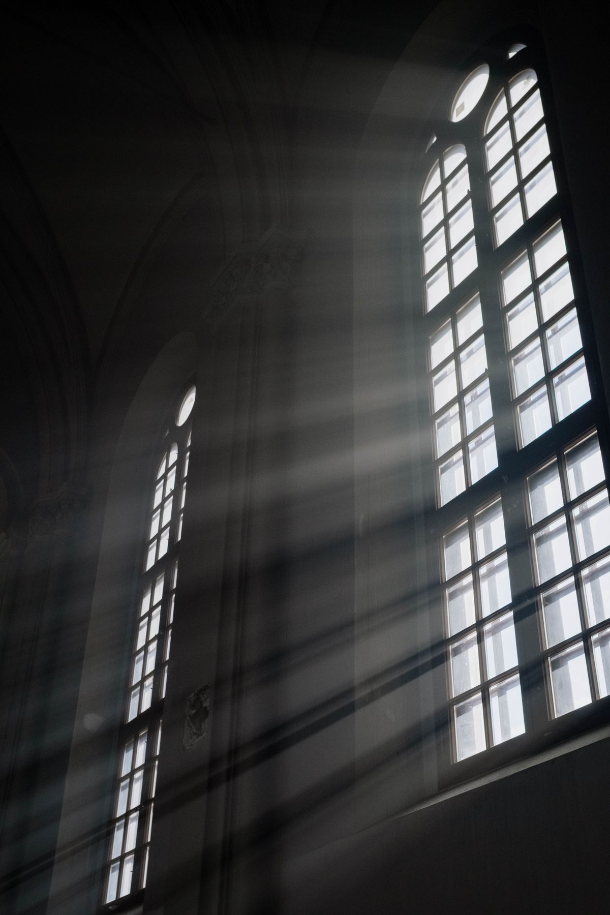 Interior de igreja católica com luz dourada entrando pelas janelas