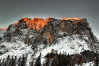 夕阳的温暖光芒照亮了白雪皑皑的壮丽山峰，风景优美而宁静