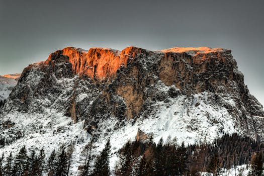 夕阳的温暖光芒照亮了白雪皑皑的壮丽山峰，风景优美而宁静