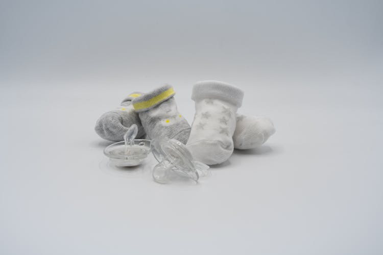 Socks And Pacifiers On White Surface