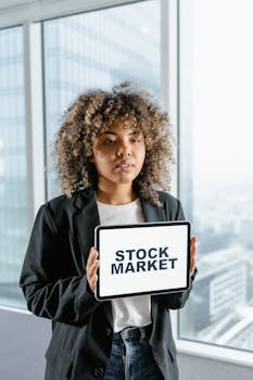 Professional woman showcasing stock market information on a tablet indoors.