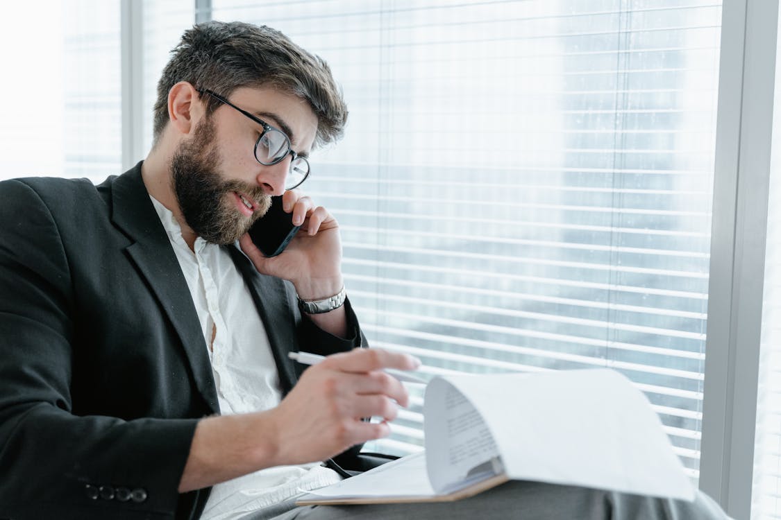 A Man in Black Suit Talking on His Cellphone