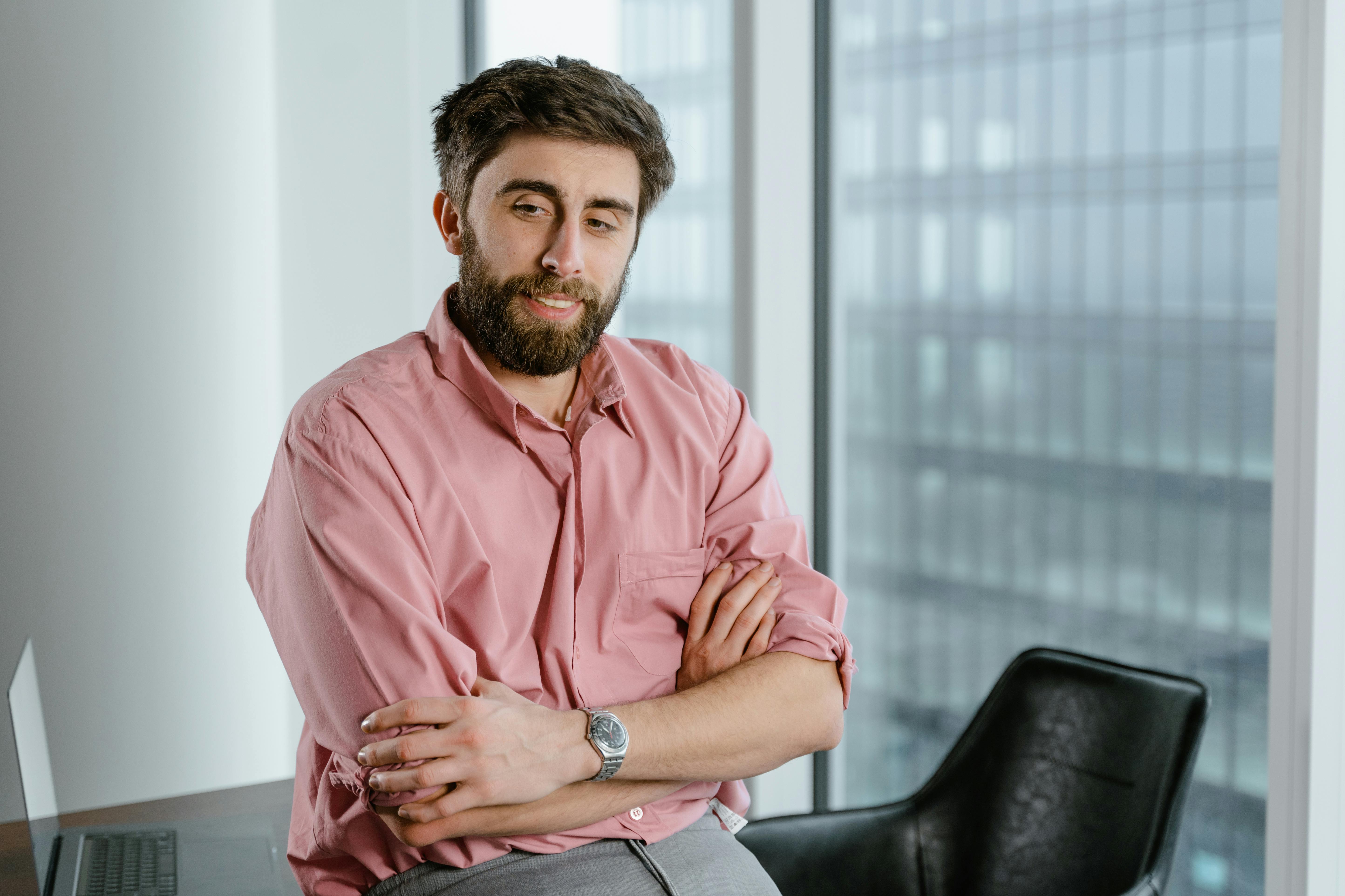 man in pink dress shirt wearing silver watch