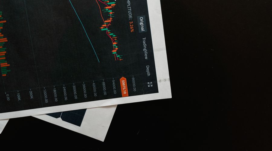 Close-up of a detailed financial chart on a dark surface showing price movements and market analysis