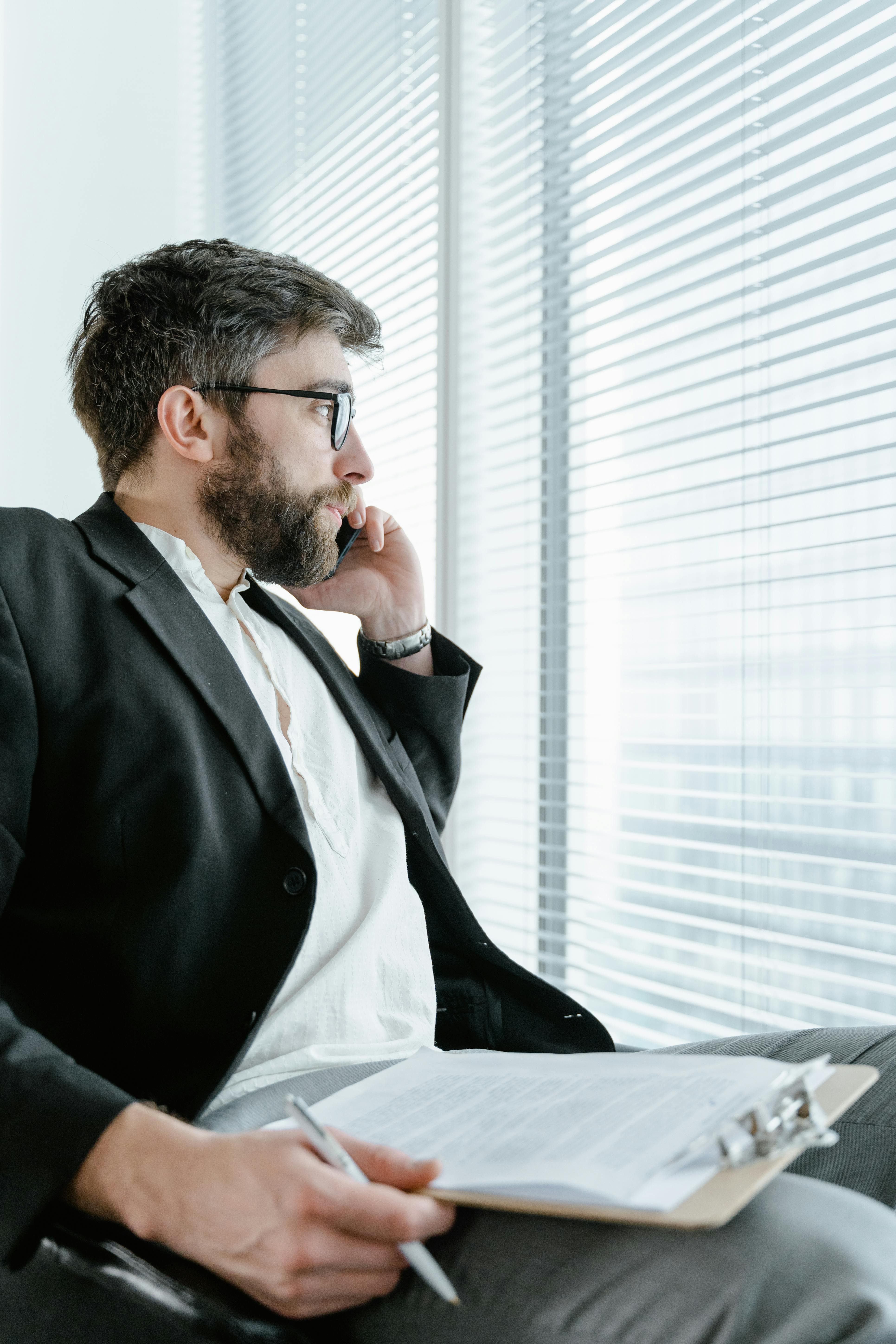 man in black suit jacket wearing black framed eyeglasses