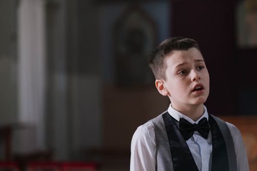 Free Portrait of a young choir boy singing with emotion in a church setting. Stock Photo