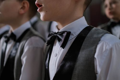Free Young boys dressed in formal wear singing in a choir, focused on elegance and unity. Stock Photo